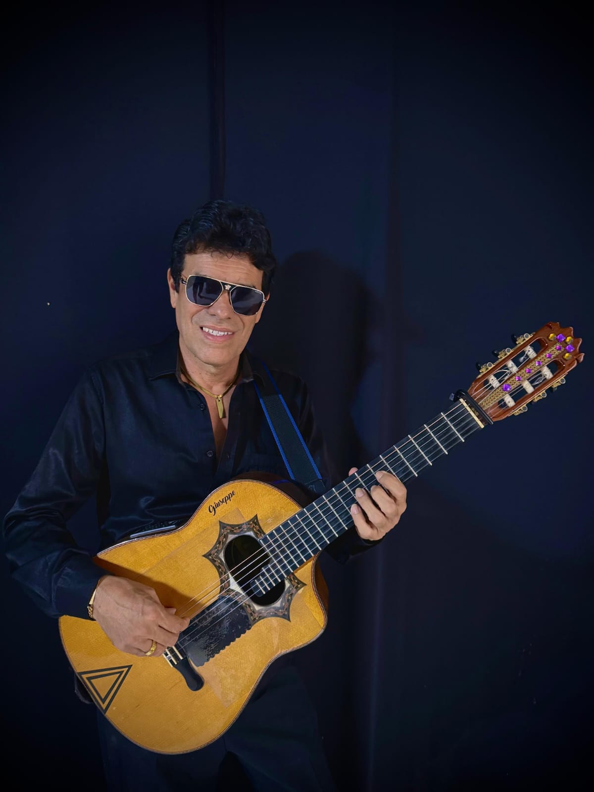 Retrato de Giuseppe sosteniendo su requinto firma con incrustaciones distintivas